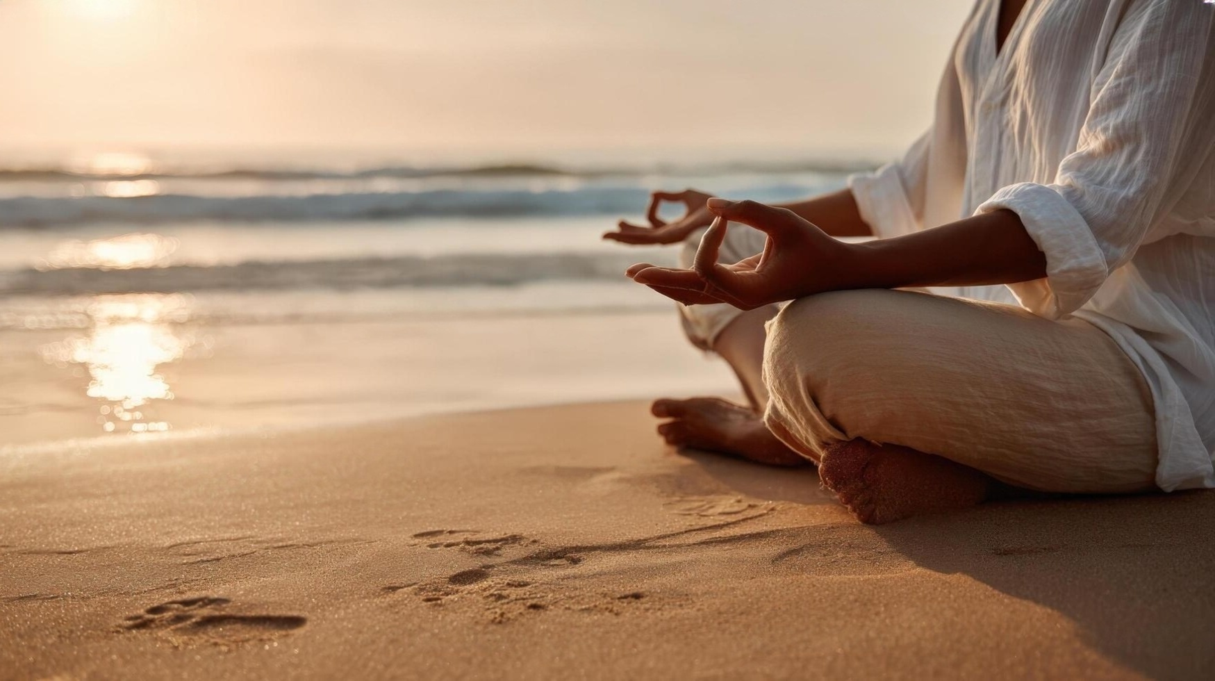 A MeiSara practitioner in a seated meditation pose by the water at sunrise